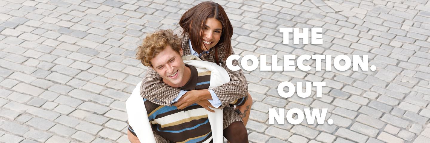 Ein lachendes Paar in modischer Kleidung steht auf einem gepflasterten Weg, daneben der Text: "THE COLLECTION. OUT NOW."